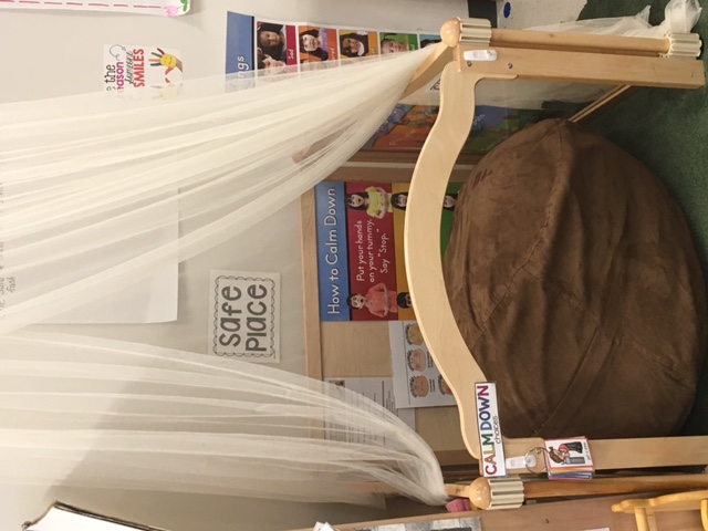 A comfortable chair and other materials in a classroom "peace corner."