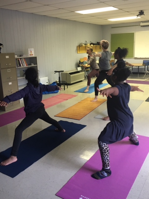 People doing yoga in a classroom.