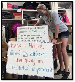 SPS AWARE Counselor Brogan Holmes prepping signs for drive through Back-to-School Event. Photo courtesy of Kehli Henry.