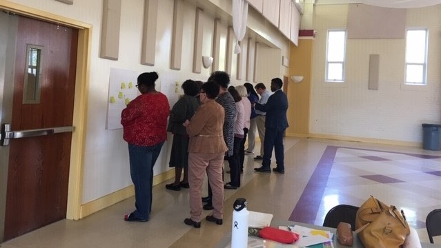 People working together on an activity on the wall of an auditorium. 