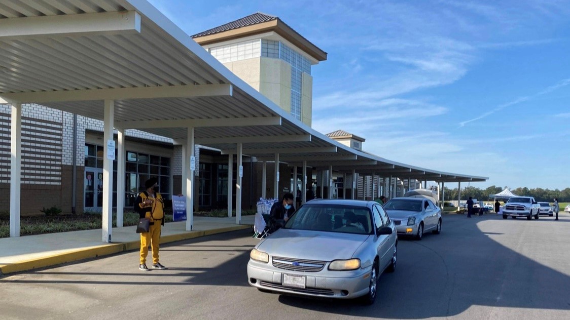 Family Resilience kit pick up event in Bennettsville, SC. Photo courtesy of Lauren Szymonik. Cars line-up in front of a building.
