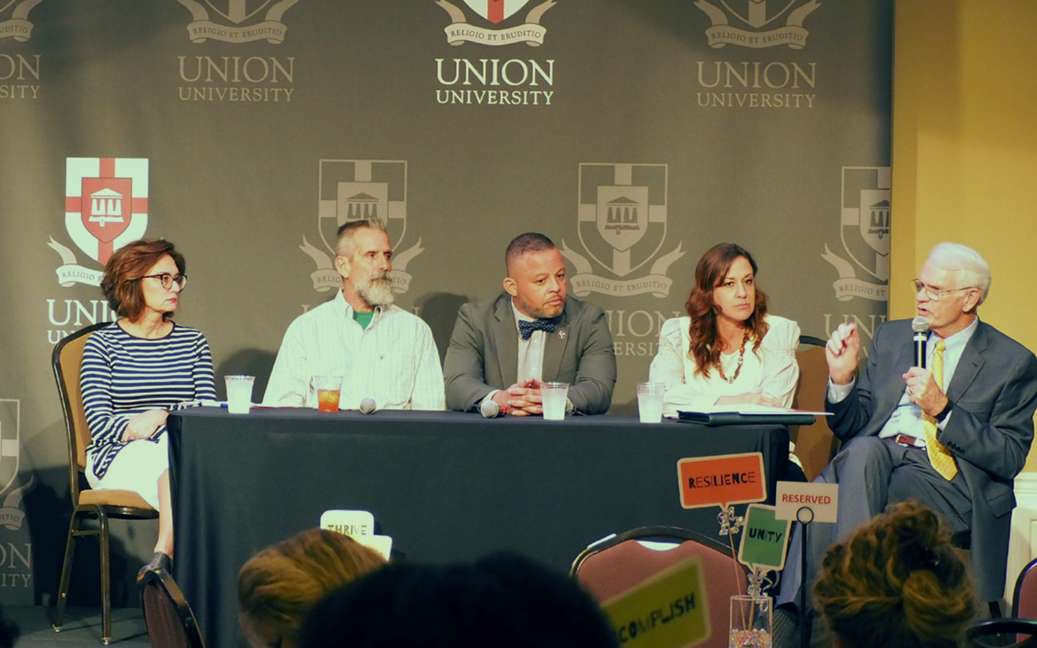 Panelists discuss strategies to build resilience in different sectors at the West Tennessee Building Strong Brains Summit, Critical Conversations [2019). Photo courtesy of Jennifer Drake-Croft. Panelists seated at a table during a conference.