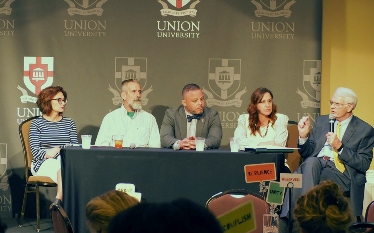 Panelists seated at a table during a conference.